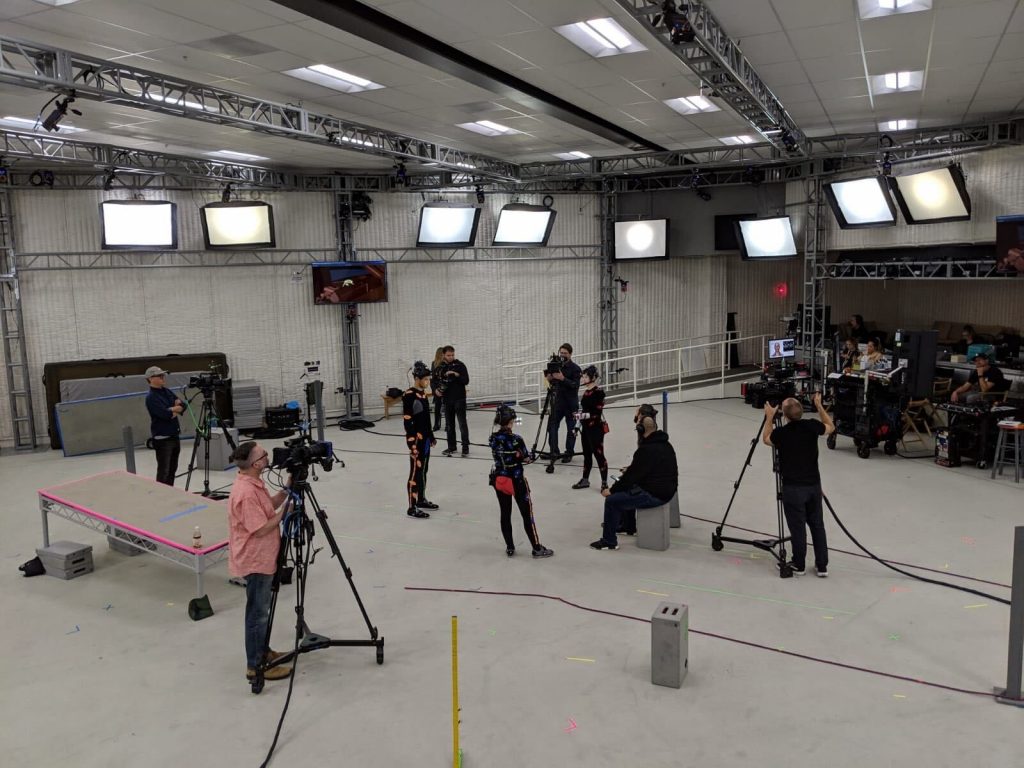 Actors in motion capture suits performing on a capture stage