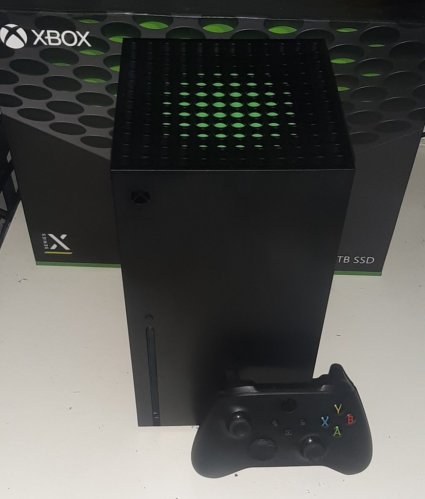 Xbox Series X console standing upright with a controller